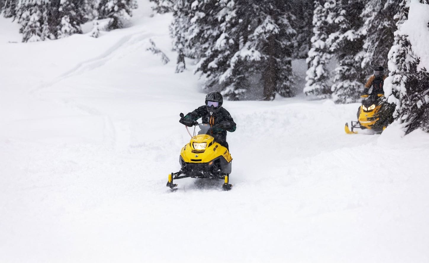 Youth riding snowmobiles