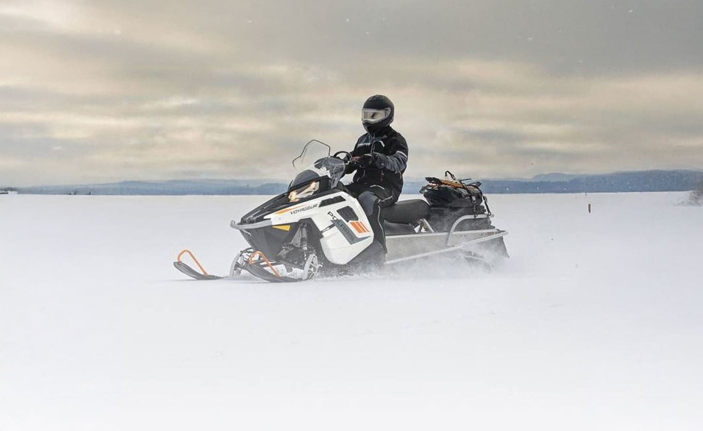 2024 Polaris Voyageur 155 riding on an open snowy plain